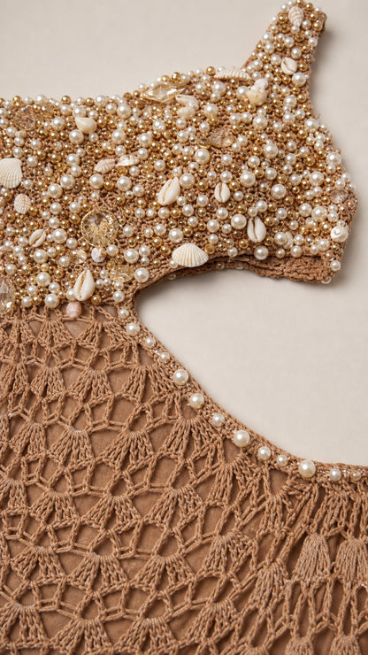 Close-up of faux pearl and shell beading on crochet dress neckline