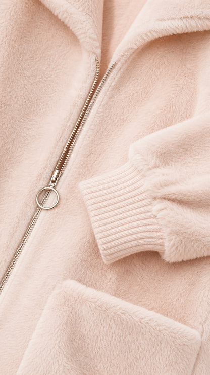 Close-up of zipper, pocket, and ribbed cuff on pink coat