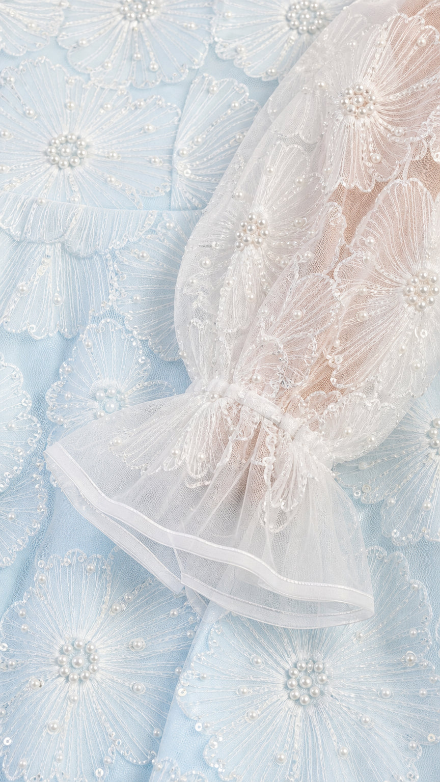 Close-up detail of floral lace embroidery and sheer flounce cuff sleeve