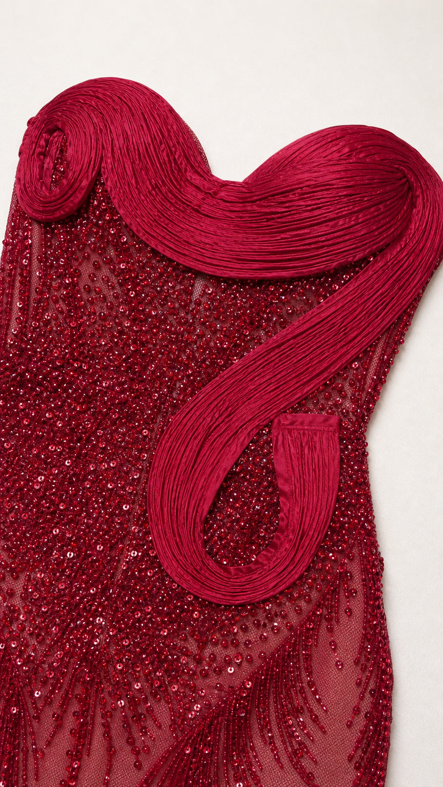 Close-up detail of red beaded fabric and sculptural bodice