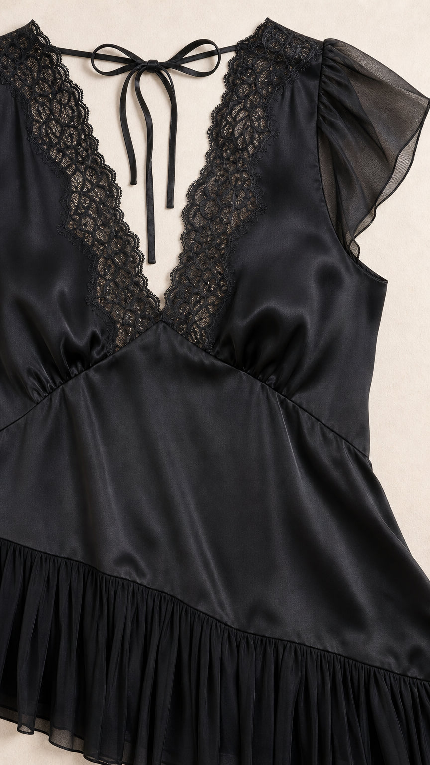 Close-up detail of V-neckline, floral lace trim, and tie closure