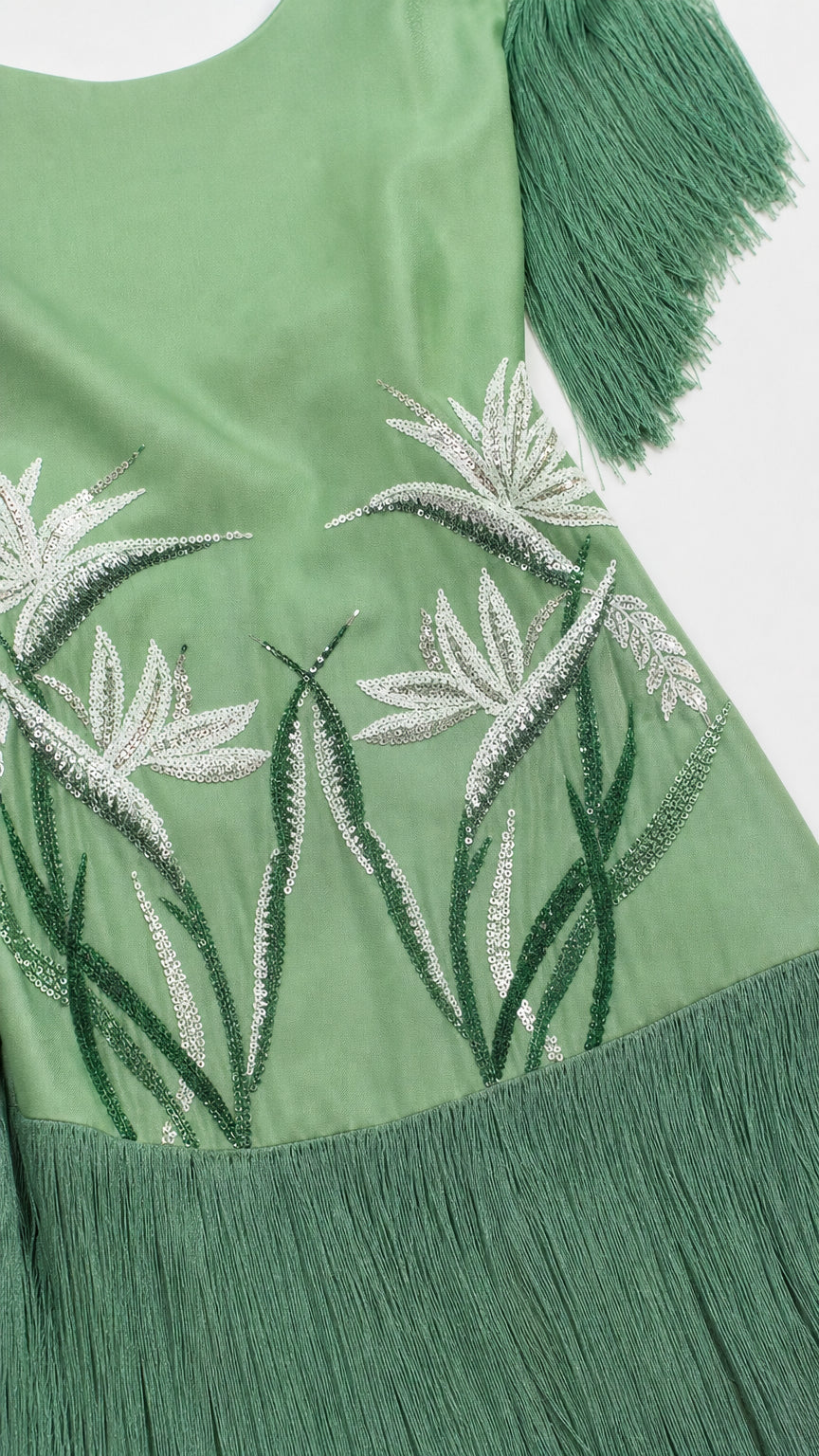 Close-up detail of white botanical embroidery on sage green fabric