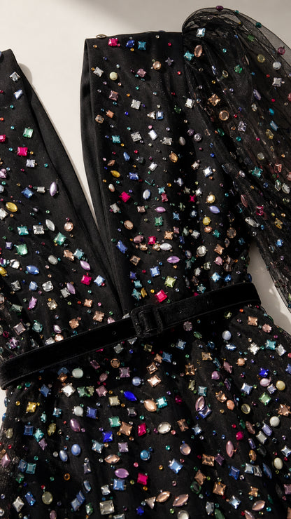 Close-up detail of multi-colored crystals and velvet waistband on black gown