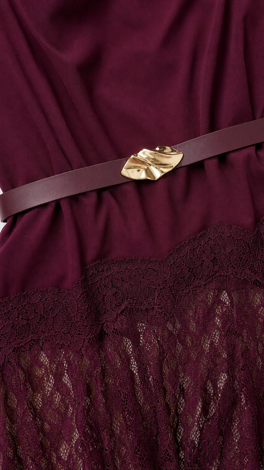Close-up detail of burgundy dress fabric, tonal belt with metallic buckle, and intricate lace overlay