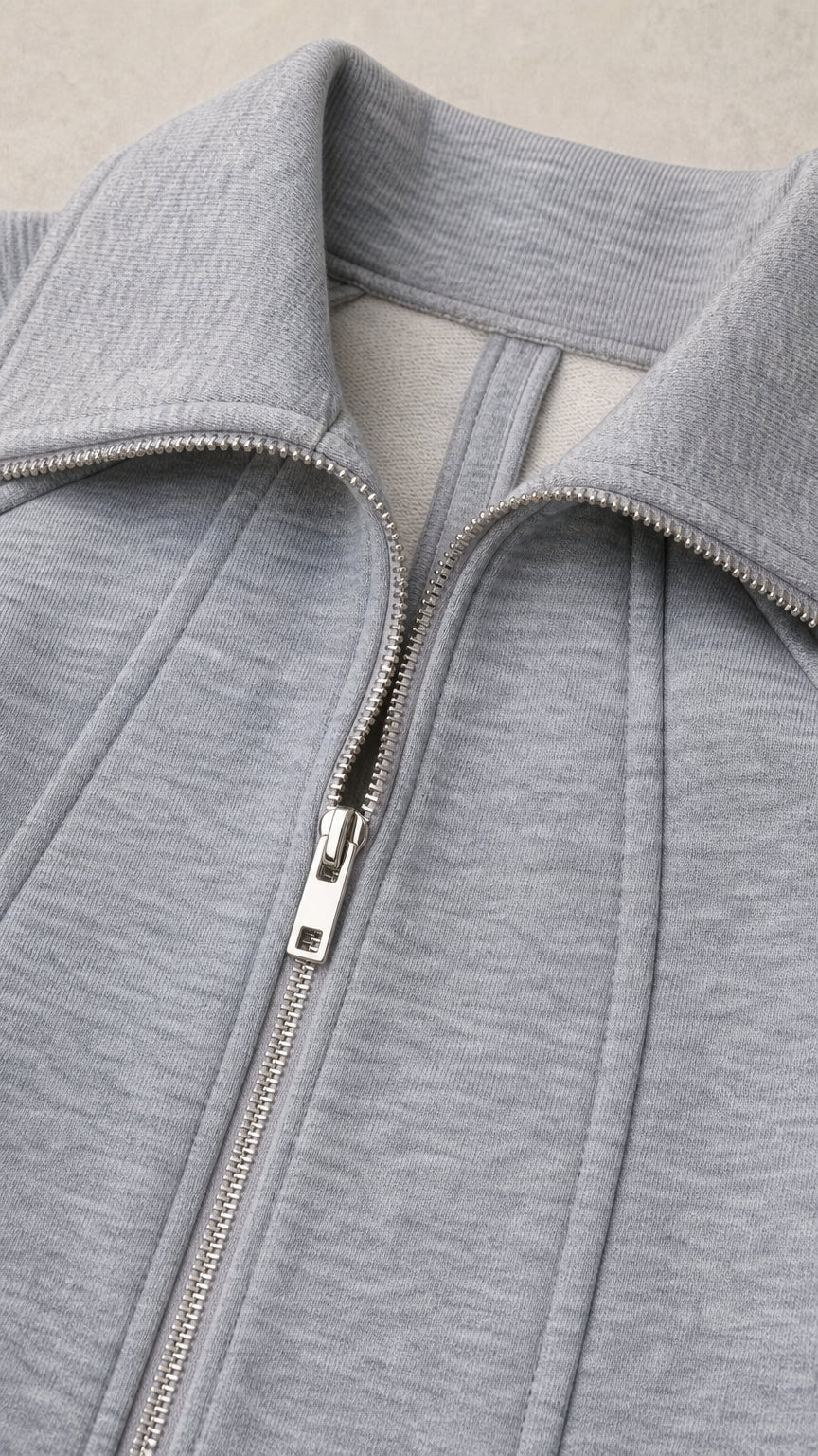 Close-up detail of zipper, collar, and knit fabric seam construction