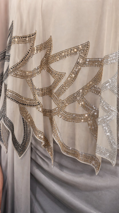 Close-up detail of the intricate sequin and bead pattern on the cape overlay