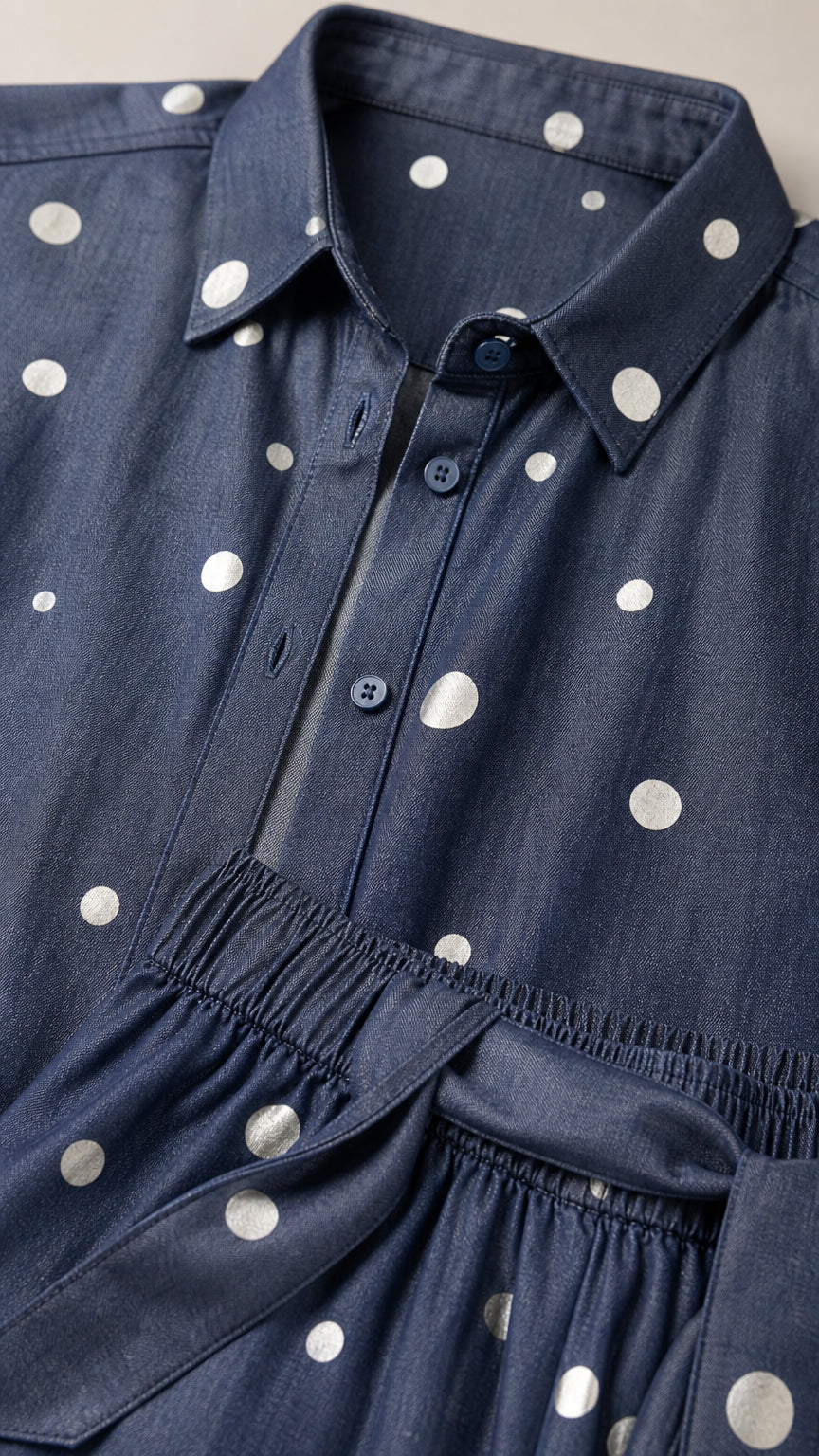 Close-up detail of denim blue polka dot shirt collar, buttons, and matching sash waistband