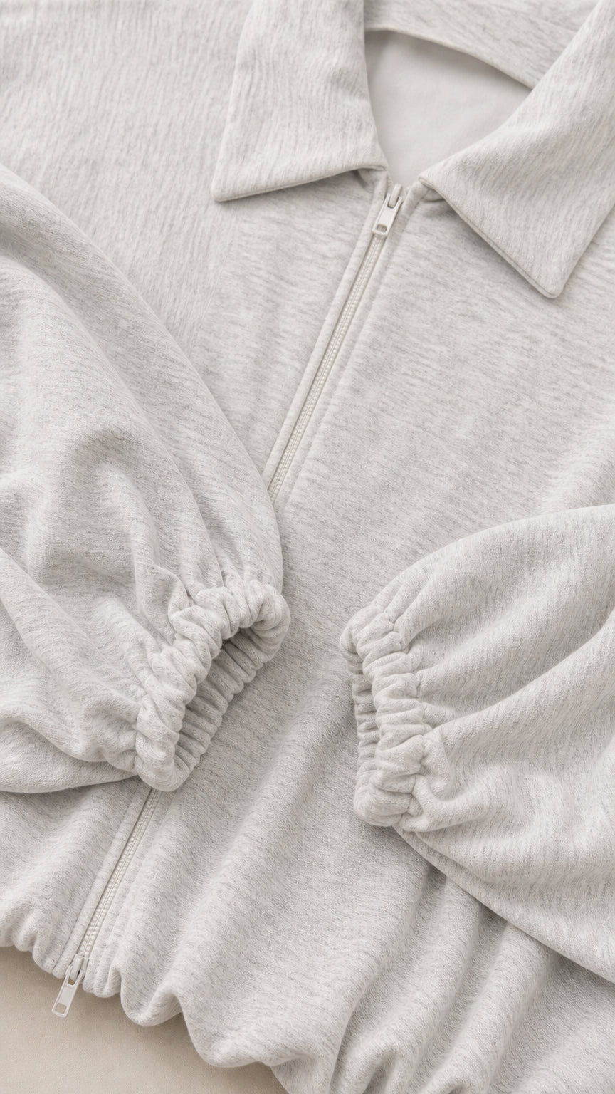 Close-up detail of heather grey zip collar and elastic ruched cuffs