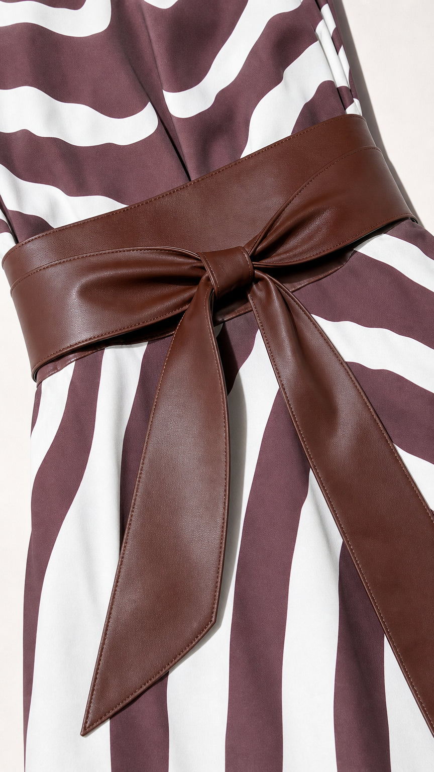 Close up of faux leather bow belt on zebra dress