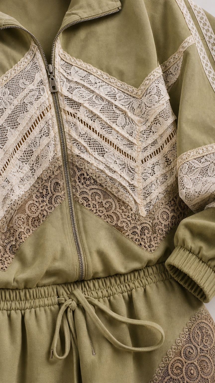 Close-up detail of zipper, collar, and geometric lace inserts on sage green jacket