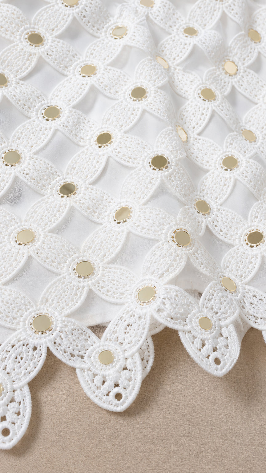Close-up detail of white lace pattern and hardware accents