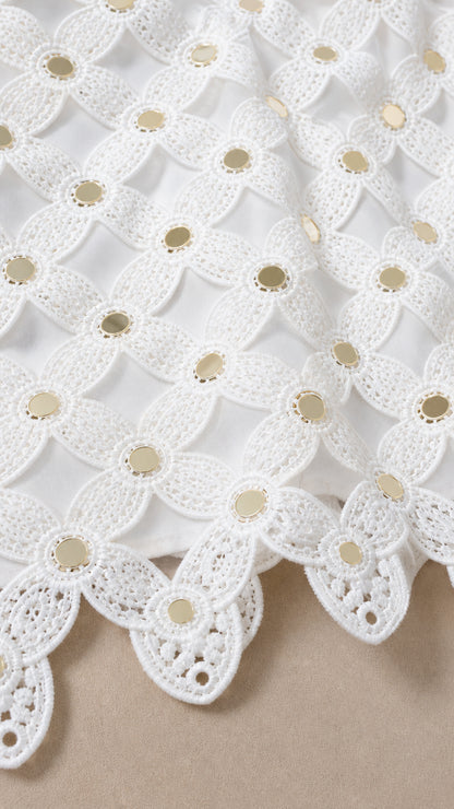 Close-up detail of white lace pattern and hardware accents