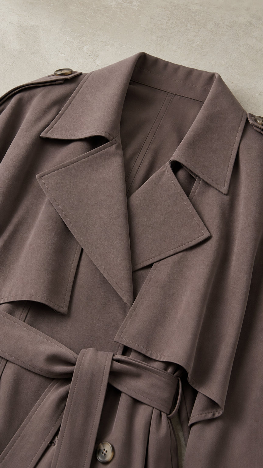 Close up of dark taupe trench coat lapel and belt