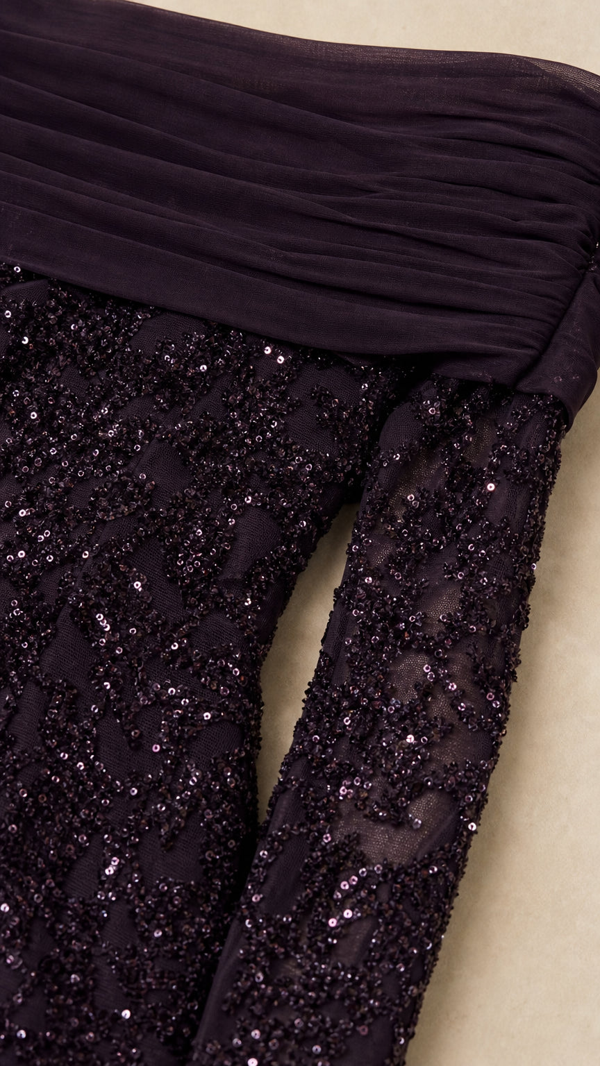 Close-up detail of dark plum draped neckline and sequin sleeve