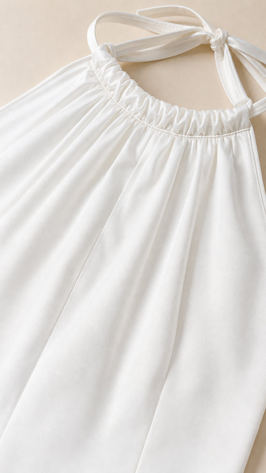 Close-up detail of white halter neckline and fabric texture