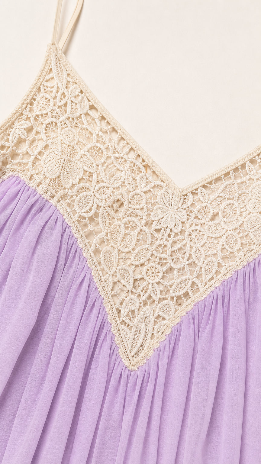 Close-up detail of cream crochet lace V-neck bodice on pleated lavender fabric