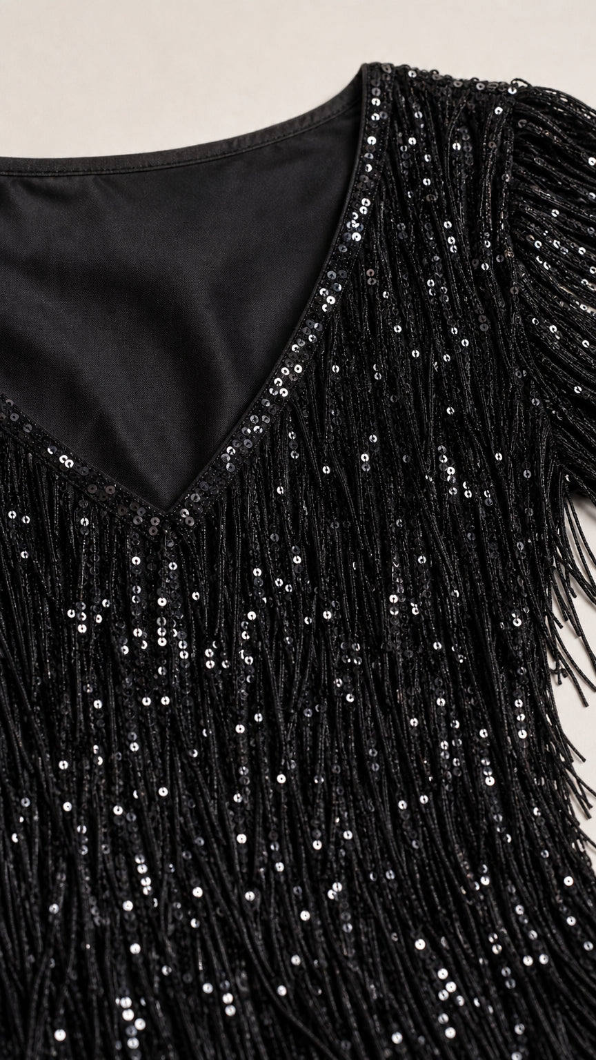Close-up detail of V-neckline and black sequin fringe texture