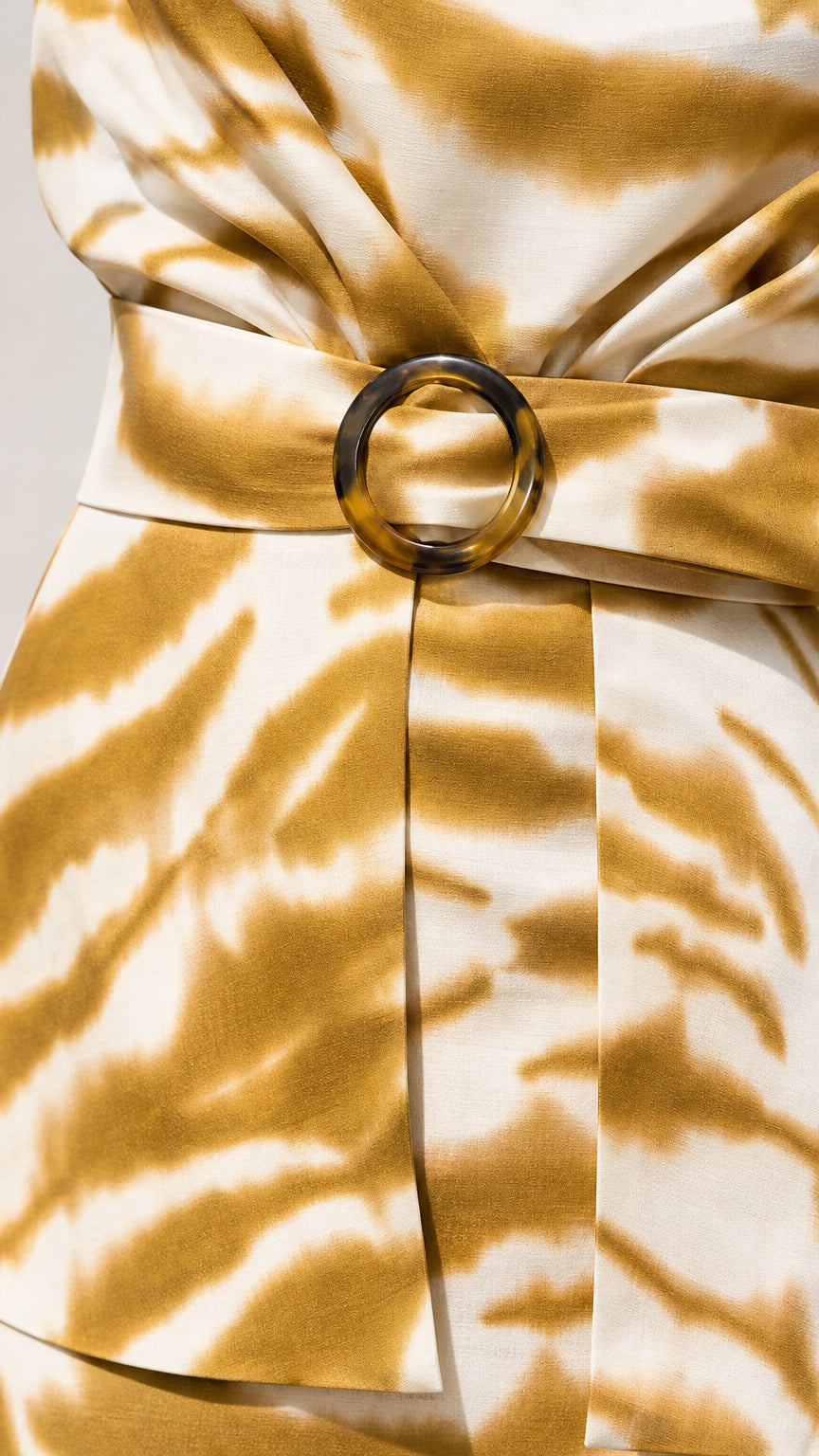 Close-up detail of belted waist with tortoiseshell ring buckle