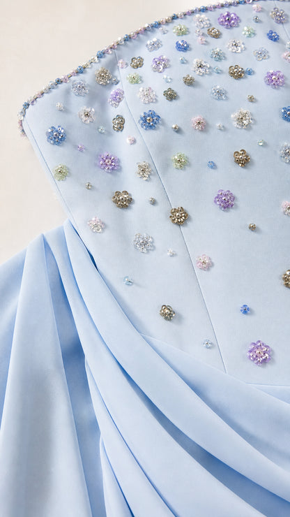 Close-up detail of multi-color floral crystal and bead embellishments on bodice and pleated waistline