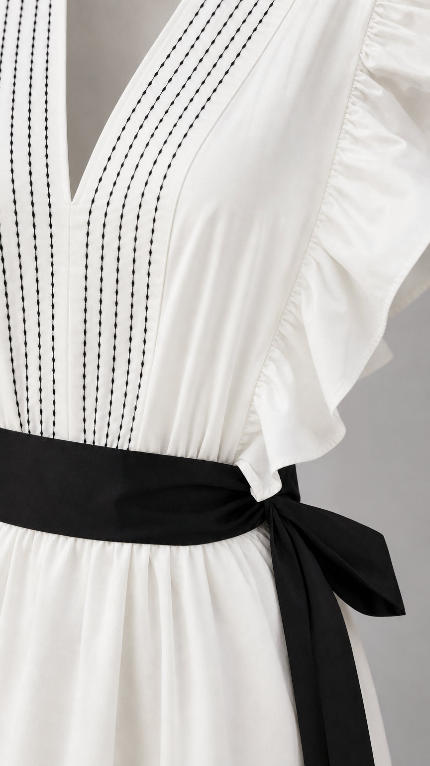 Close-up of bodice, V-neck stitching, and black sash