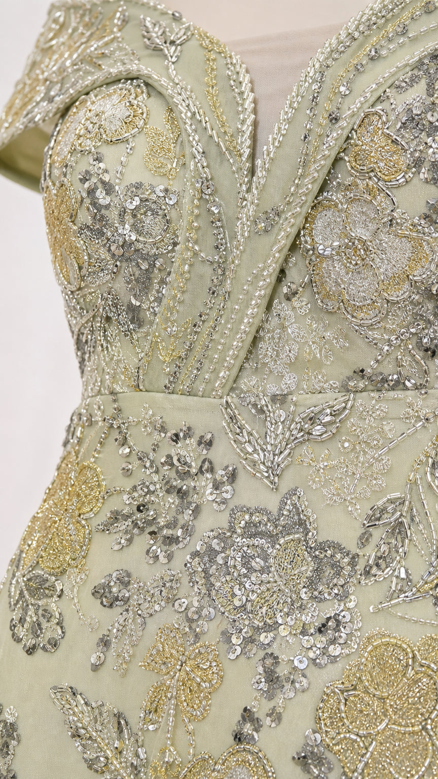 Close-up of floral and paisley-style silver and metallic embellishment on sage green gown fabric