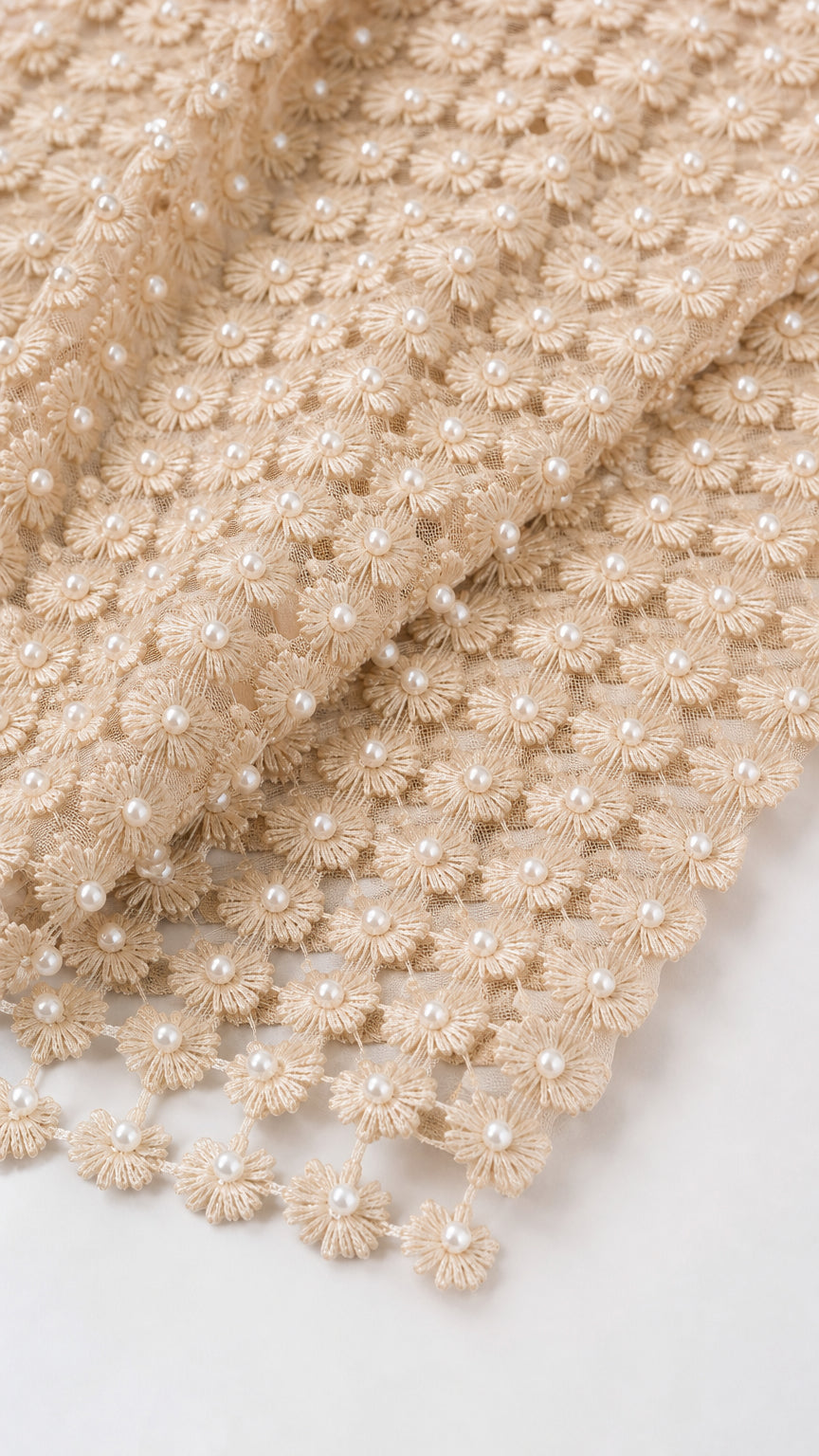 Close-up of beige 3D textured fabric with pearl details