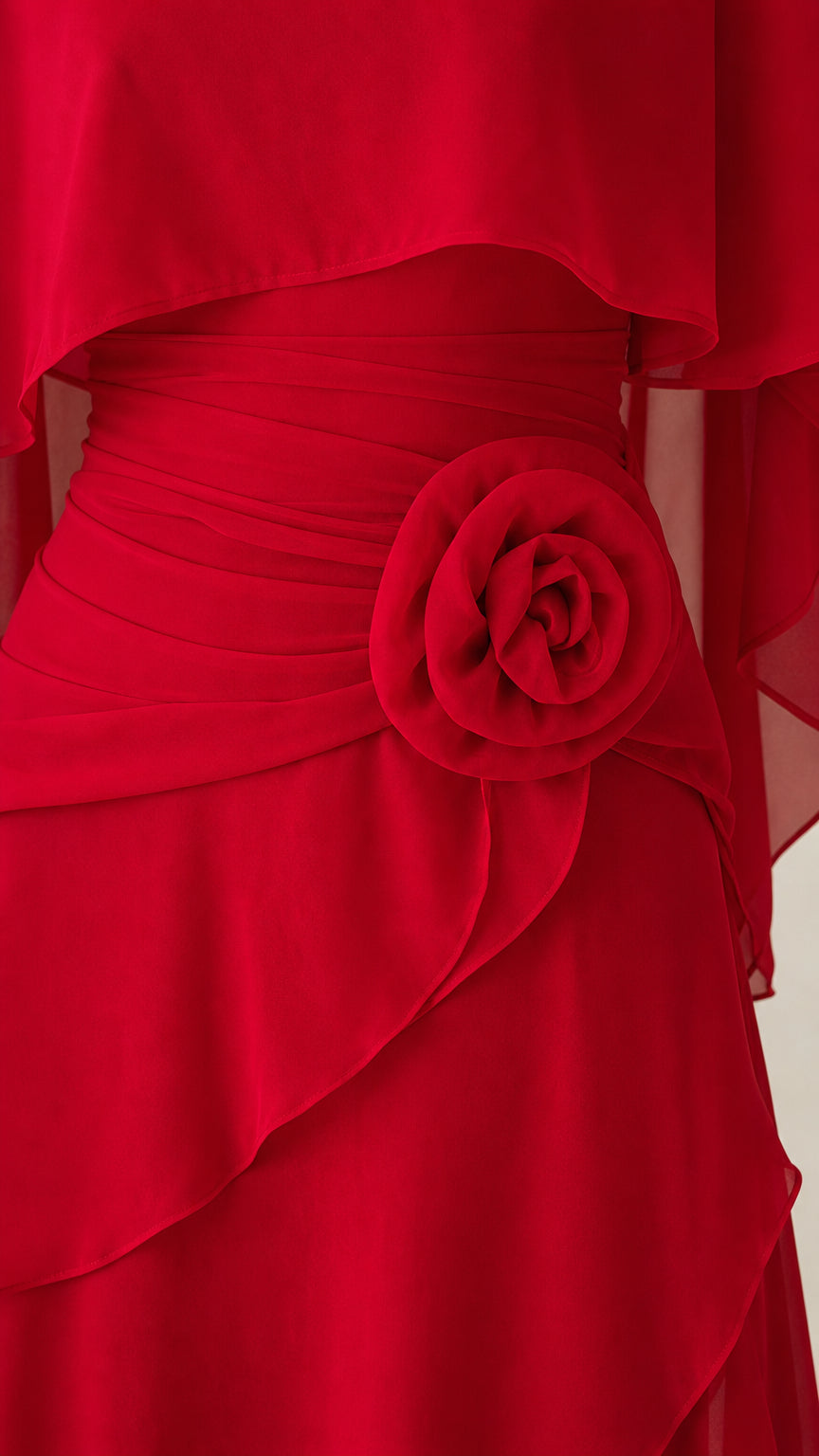Close-up detail of the fabric rose accent on the waist of the red dress