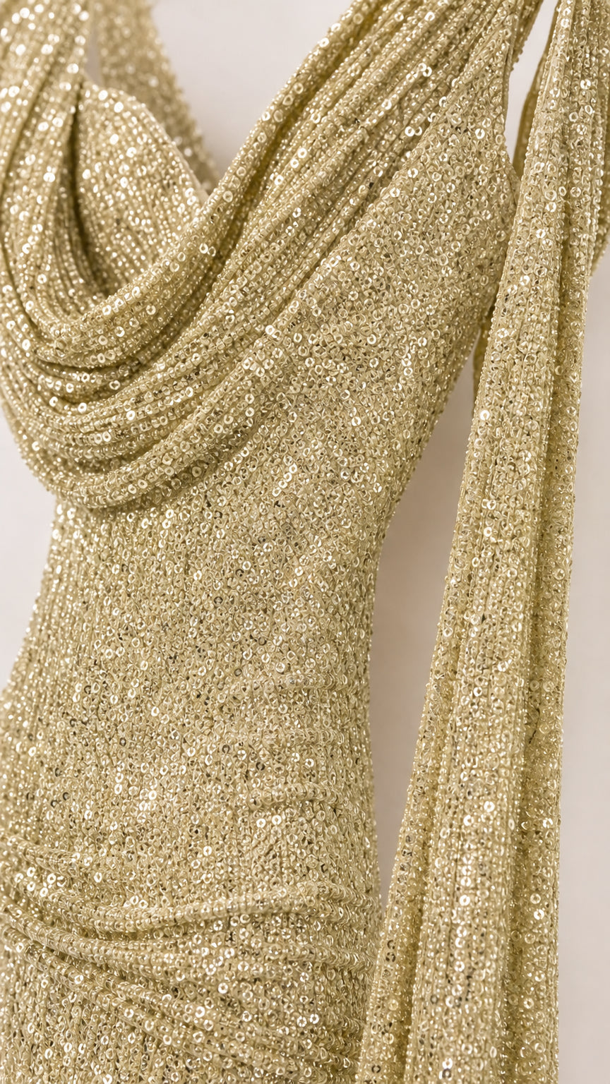 Close-up of gold sequin fabric and draped cowl neckline detail