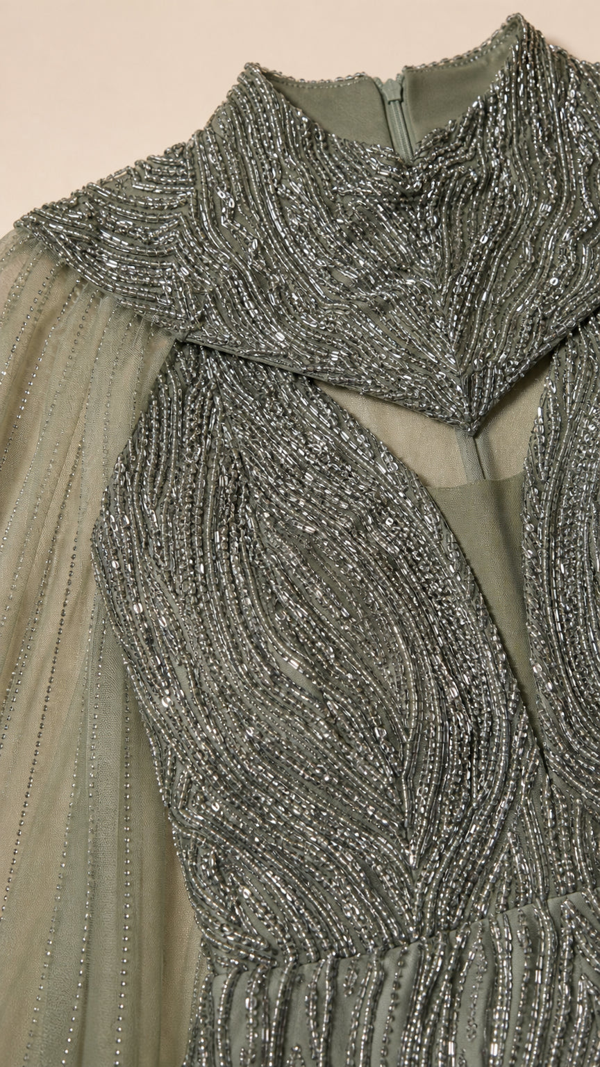 Close-up of intricate silver and green beadwork and cutout high collar