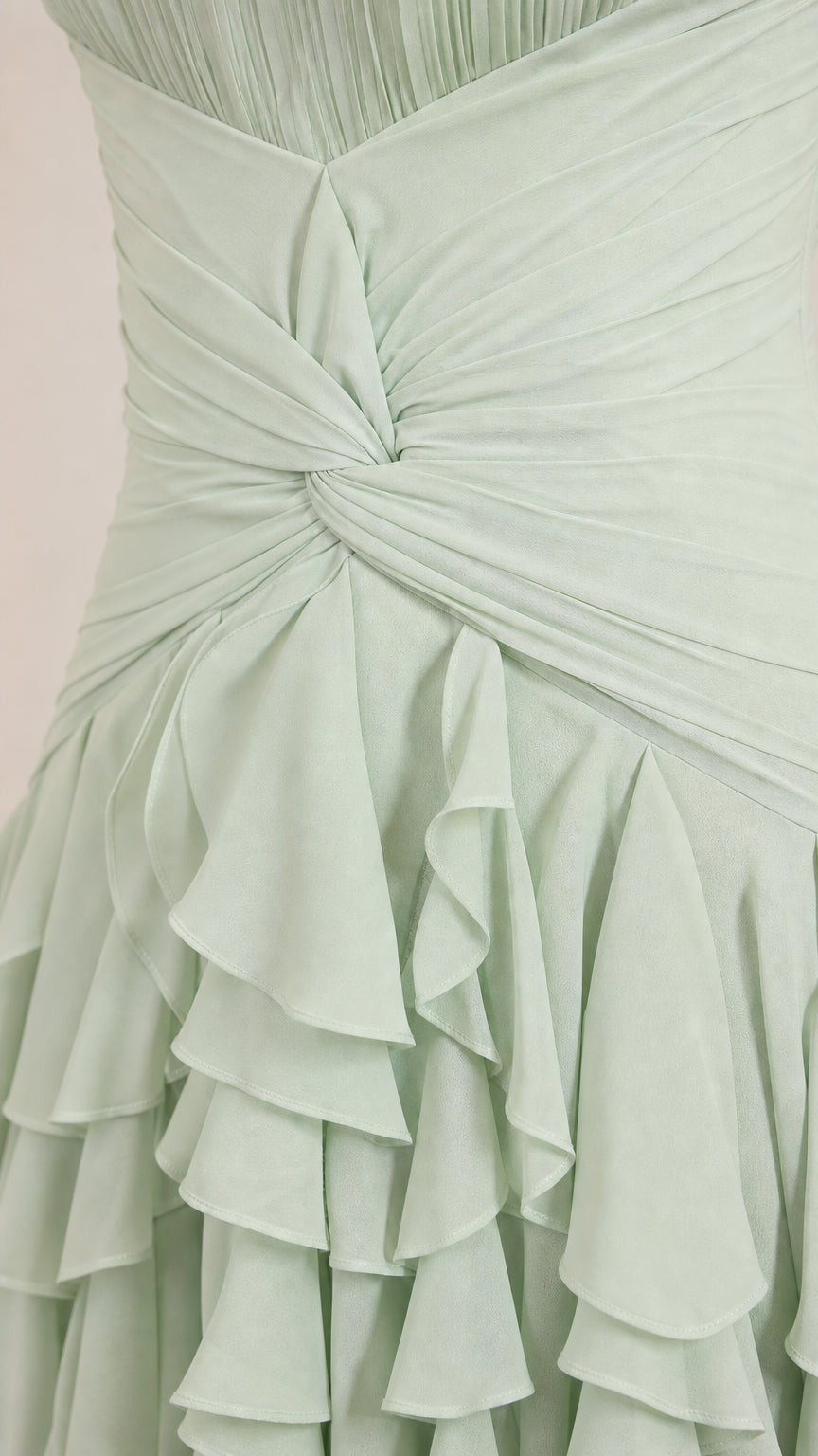Close-up detail of twisted bodice and ruffle texture on sage green dress