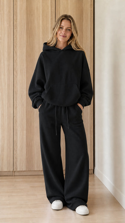 Model wearing a black women's hoodie and wide-leg sweatpants set