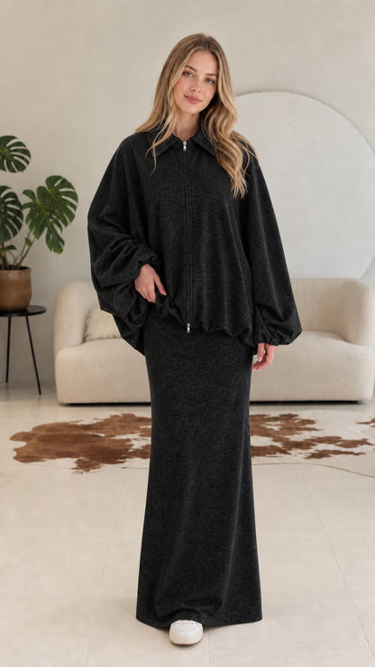 Model wearing charcoal black two-piece collared zip jacket and maxi skirt set