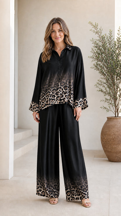 Woman wearing black satin leopard ombre pant set