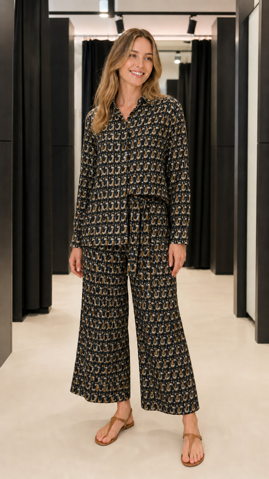 Woman wearing black geometric print matching shirt and trousers set