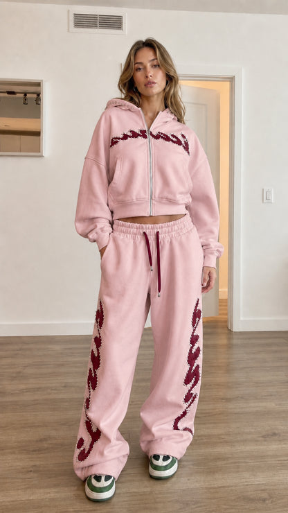 Model wearing light pink cropped zip hoodie and wide leg sweatpants set