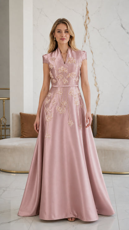 Model wearing dusty pink satin formal gown with floral embellishment