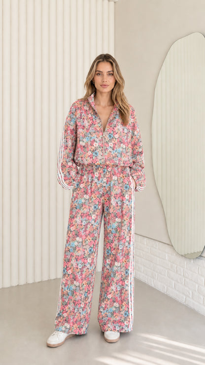 Woman wearing pink floral print zip-up tracksuit two-piece set