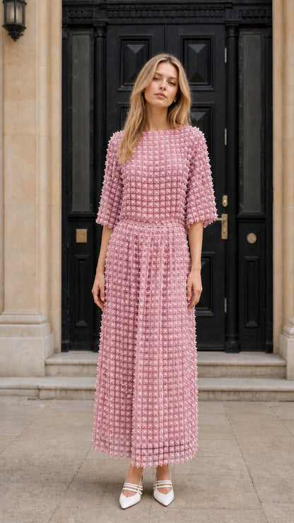 Front view of model wearing pink textured pearl embellished midi dress