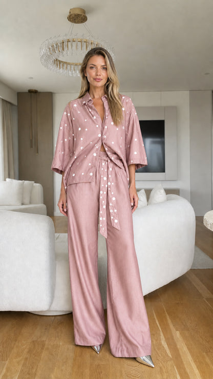 Model wearing dusty pink polka dot blouse and matching wide-leg trousers set