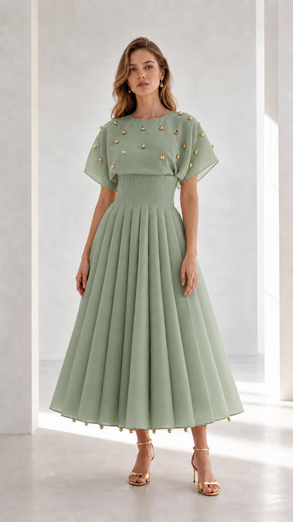 Front view of model wearing sage green studded pleated midi dress with flutter sleeves