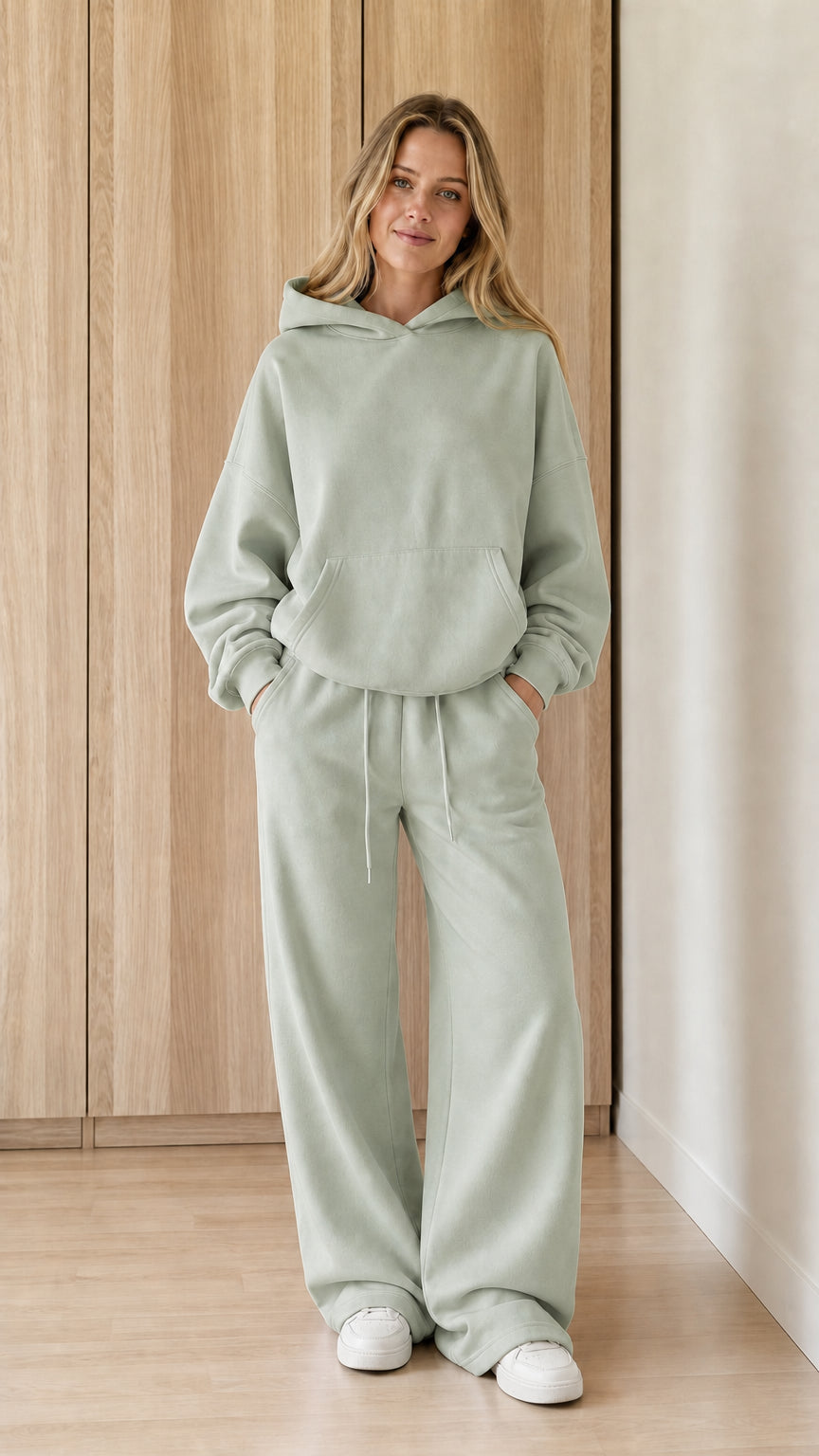 Model wearing a sage green women's hoodie and wide-leg sweatpants set