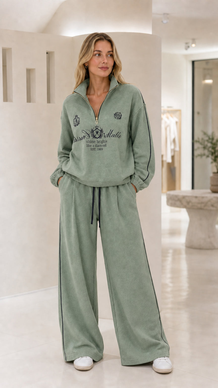 Woman wearing the sage green quarter-zip wide-leg tracksuit set