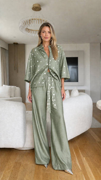 Model wearing sage green polka dot collared top and matching wide-leg trousers set