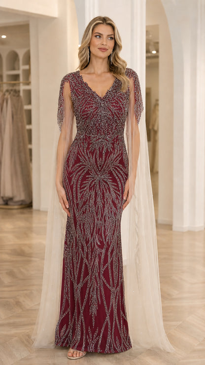 Front view of model wearing Burgundy sequin embroidered V-neck evening gown with sheer shoulder cape