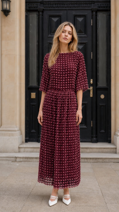 Front view of model wearing burgundy textured pearl embellished midi dress