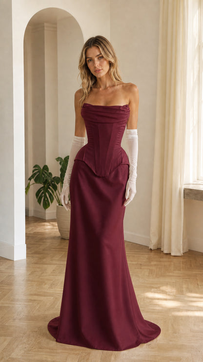 Front view of woman wearing burgundy strapless corset maxi dress with matching gloves