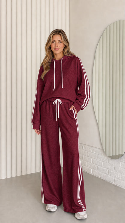 Front view of the burgundy women's striped hoodie and wide-leg pants set