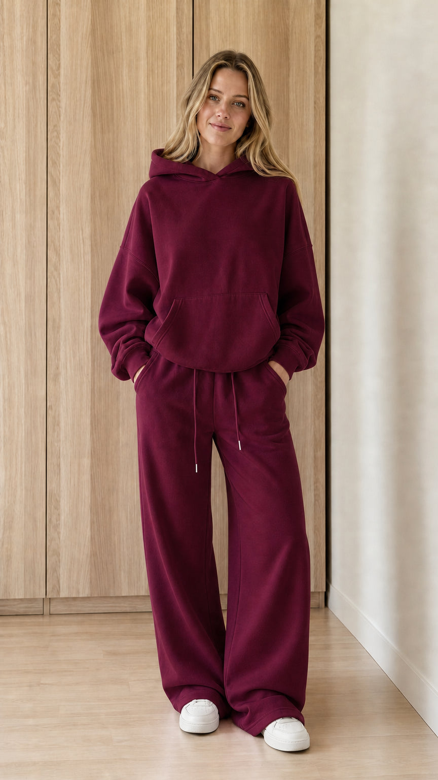Model wearing a burgundy women's hoodie and wide-leg sweatpants set