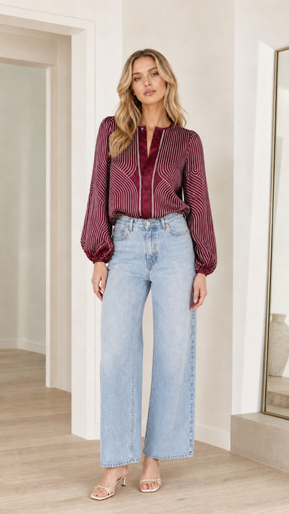 Model wearing burgundy striped satin blouse