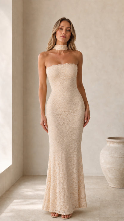 Front view of model wearing champagne strapless lace maxi dress